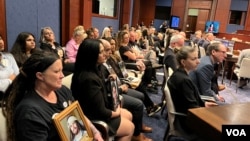 资料照片:2024年4月16日,美国芬太尼危机受害者家属在国会众议院中共问题特设委员会针对芬太尼泛滥问题召开的听证会上手拿家人的照片聆听会议。(美国之音记者李逸华摄)