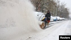 一名工人在北京街头扫雪。(2023年12月14日)