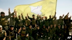 资料照片:2019年3月23日,美国支持的叙利亚民主力量战士在叙利亚巴古兹拍照。(美联社照片)