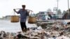 FILE - Seorang lelaki berjalan melewati tumpukan sampah di sebuah pantai di perkampungan nelayan Teluk Pandeglang, Banten, 15 Maret 2024. (Willy Kurniawan/REUTERS)
