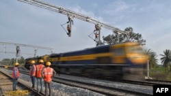 印度铁路公司的合同工在班加罗尔郊区架设用于在铁轨上牵引电缆线供机车使用的设施。(资料照片,2021年1月15 日)