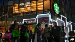 资料照片:北京一条商业街上的星巴克咖啡店。(2023年12月23日)