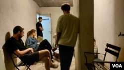 10月16日特拉维夫市中心, 警报声响起后，住在公寓楼的人们躲进楼底掩体里躲避火箭弹 (美国之音/唐丹鸿)