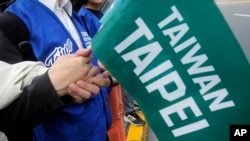 资料照:在台湾举行的一次公投中,台湾民众手举“台湾台北”的旗子,表示反对“中国台北”,的台湾身份表达的政治意愿。(2018年11月3日)