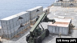 2024年4月26日,在美国陆军提供的这张图片中,分配到第7运输旅(远征)的陆军士兵和隶属于“罗伊·贝纳维德斯号”滚装货轮的水手在加沙海岸组装浮动码头。(美联社照片)