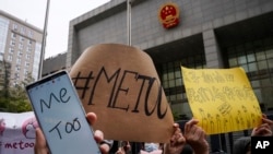 资料照 - 2020年12月2日,一位名叫周晓轩(音译)的中国女子控告被性骚扰案件在北京一法院开庭审理。照片显示支持周晓轩的人群在法庭外举牌声援。