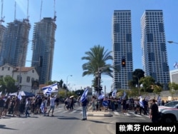 10月14日从早上开始在特拉维夫市中心的国防部大楼旁的街道上聚集的群众,原本是为被哈马斯挟持的人质声援并支持人质家属的守夜抗议行动、下午分成为两阵营,街道左边强调声援人质,街道右边演变为对政府不满的抗议。(美国之音 赖素芬)