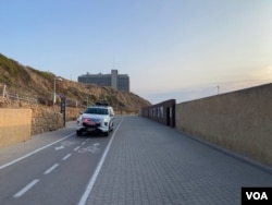 平常熙熙攘攘非常受居民和观光客喜欢的特拉維拉海边步道和自行车道空无一人、只見巡逻警车。(美国之音 赖素芬)