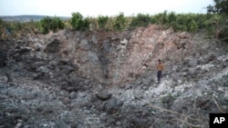 2023年4月7日A 黎巴嫩南部的加里里村一位村民站在以色列空袭后造成一个巨大弹坑里。