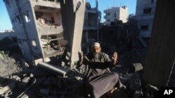 2023年12月15日,一名巴勒斯坦人在以色列袭击加沙地带拉法的住宅楼后作出反应。(美联社照片)