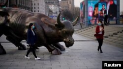 资料照：行人走过上海外滩金融牛旁。（2020年3月18日）