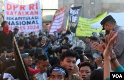 Para demonstran di depan Gedung DPR/MPR, Senayan, Jakarta saling dorong dengan aparat kemanan, Selasa (19/3). (foto: Indra Yoga/VOA).