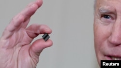 拜登总统在白宫签署有关解决全球半导体芯片短缺的行政令期间手拿芯片发表讲话。（2021年2月24日）
