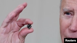 拜登总统在白宫签署有关解决全球半导体芯片短缺的行政令期间手拿芯片发表讲话。(2021年2月24日)