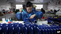 新华社2023年2月23号发表的照片显示,中国河北省武强县一家工厂的工人正在装配一种西方乐器。中国工厂的生产活动从今年2月开始逐渐增速。