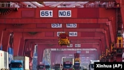 集装箱船正在中国山东省青岛港进行卸载。(2024年2月11日)