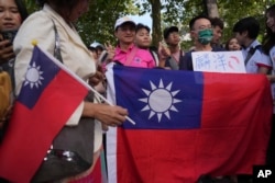 来自台湾的李洋和王齐麟赢得2024巴黎奥运会羽毛球男双金牌后,台湾球迷在羽毛球赛场Porte de La Chapelle Arena外展示台湾旗帜参加庆祝活动。(2024年8月4日)