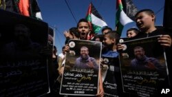 巴勒斯坦少年手举伊斯兰激进圣战组织成员阿德南画像抗议他死于以色列的狱中。(2023年5月2日)