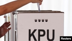 FILE: Seorang pemilih memasukkan surat suaranya ke dalam kotak suara di sebuah TPS di Jakarta, 17 April 2019. (REUTERS/Edgar Su)