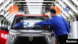 资料照片:在中国山东省青岛,工人在合资企业上汽通用五菱的一家工厂内的“宝骏 E200”电动汽车组装线上工作。(2018年9月28日)