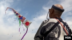 风筝大师土岐干男的美日友好风筝,长100米,各有50面美日国旗,梅花间竹的排列着 (美国之音/莫干生)