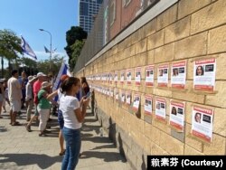 声援人质的参与者在处于特拉维夫市中心的国防部外墙上张贴附有人质照片的海报,形成一面受害者的海报墙,群众可逐一知悉受害者的脸孔、姓名和年龄,停留观看的民众心情沉重,仿佛是纪念碑。(美国之音 赖素芬)