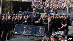 2023年8月15日,波兰总统杜达在抵达波兰华沙参加大规模阅兵式时向部队致意。(美联社照片)