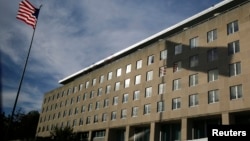资料照片:一面美国国旗在美国国务院位于首都华盛顿的哈里·杜鲁门大楼前飘扬。(2014年10月24日)