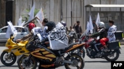 2023年8月15日,塔利班支持者在喀布尔庆祝接管阿富汗政权两周年期间骑着挂有塔利班旗帜的摩托车。(法新社照片)