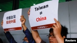 资料照:支持台湾独立的人士在台北桃园国际机场举牌抗议台湾前总统马英九前往中国大陆的旅行。(2023年4月7日)