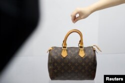 资料照:北京的一家二手奢侈品商店的职员在布置展品。(2020年10月10日)