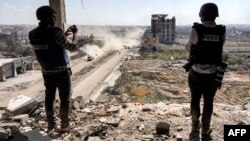 FILE: Para jurnalis mengambil gambar dari atas gedung yang rusak menghadap gedung rumah sakit Al-Salam yang hancur di Khan Yunis, 7 April 2024 setelah Israel menarik pasukan daratnya keluar dari Jalur Gaza selatan. (AFP)