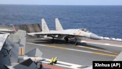 资料照:中国军队在台湾周边海域举行军演,一架歼-15战机准备从山东号航母上起飞。(2023年4月9日)