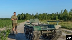 2024年6月28日,乌克兰北部的一片玉米地里,设计和生产局“UkrPrototyp”的首席执行官安德烈·丹尼森科站在800公斤的地面无人机原型机“奥德赛”旁。(美联社照片)