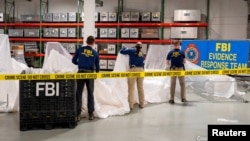 在一个未公开地点拍摄的照片显示,联邦调查的特工正在处理从南卡罗来纳州海岸被美军喷气式飞机击落的高空中国气球中回收的材料。(照片由美国联邦调查局提供。)