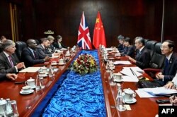 中国外长王毅（右二）与英国外相拉米（David Lammy）在老挝万象出席东盟外长会议期间举行会谈。（2024年7月26日）