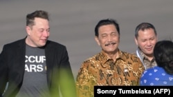 Miliarder teknologi Elon Musk berjalan bersama Menteri Koordinator Kemaritiman dan Investasi Luhut Binsar Pandjaitan saat tiba di bandara Internasional Ngurah Rai di Denpasar, 19 Mei 2024. (Foto: AFP/Sonny Tumbelaka)
