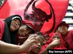 Para pendukung Partai Demokrasi Indonesia Perjuangan (PDI-P) saat mengikuti kampanye untuk pemilu 2004 di Jakarta, 23 Maret 2023. (Foto: Bay Ismoyo/AFP)
