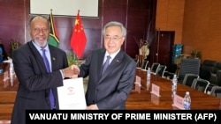 瓦努阿图总理办公室2024年7月2日发布图片显示,瓦努阿图总理萨尔瓦伊(左)与中国全国政协副主席胡春华在新总统府的正式移交给瓦努阿图政府的仪式上握手。