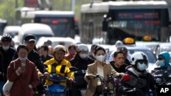 北京金融区街头早高峰时间的上班车辆人群。(2023年4月18日)