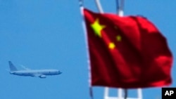 在美国海军一艘军机在天上盘旋监控下,两艘菲律宾供应船在一次危险的对峙中突破了中国海警船在托马斯第二浅滩附近的封锁。(美联社2023年8月22日)