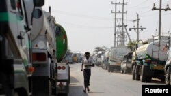 ရန်ကုန်မြို့ သီလဝါဆိပ်ကမ်းမှာ စက်သုံးဆီဖြည့်ဖို့အတွက် တန်းစီနေတဲ့ ကားများ 