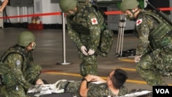 台湾空军花莲基地星期二(7月23日)操演战伤救护,在机棚内紧急开设伤员集结点,检伤分类后,快速后送(美国之音特约记者庄志伟拍摄)