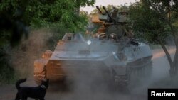 资料照片:乌军第93机械化旅的军人在巴赫穆特附近前线驾驶一辆配备高射炮的装甲车。(2024年5月23日)