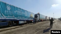 2023年10月19日,一名埃及志愿者走在载有埃及非政府组织为巴勒斯坦人提供的人道主义援助物资的卡车旁边。(路透社照片)