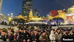 苹果在上海的静安区专卖店开张营业当日,人群在栏杆后排队等候的盛况。(2024年3月21日)