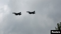 2024年8月4日,在乌克兰一个未公开的地点纪念乌克兰空军日期间看到的乌克兰F-16战斗机在空中飞行。(路透社照片)