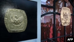 FILE- Lambang Komisi Pemilihan Umum (KPU) di pintu gerbang kantor KPU menjelang pengundian nomor suara capres dan cawapres di Jakarta, 14 November 2023. (Bay ISMOYO/AFP)