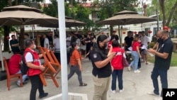 菲律宾移民局提供的照片显示,2024年8月31日,在宿务省拉普拉普市,菲律宾政府人员在突击查抄一处疑似非法在线赌博和网络诈骗综合体期间监督有关活动。