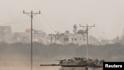 2024年1月11日,以色列南部以色列-加沙边境附近,以色列坦克从加沙重新进入以色列。